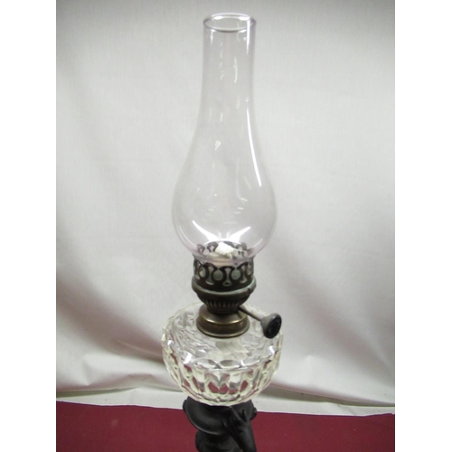 313 - Early C20th figural patinated spelter oil lamp with clear glass faceted reservoir on circular moulde... 