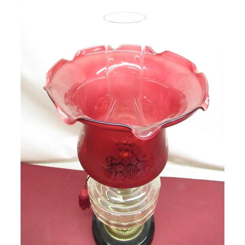 314 - Early C20th oil lamp with cranberry etched shade, clear glass reservoir, on embossed brass base, ter... 