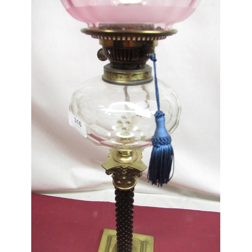 316 - Late C19th oil lamp with etched cranberry tinted shade, spherical faceted clear glass reservoir on c... 