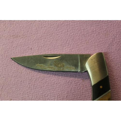 207 - 2 folding pocket knives. One by Elk Ridge (with box) with laser engraved image of a stag on the blad... 