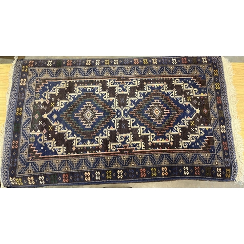 434 - C20th Caucasian pattern wool rug, blue and brown ground, central field set with two stylised geometr... 