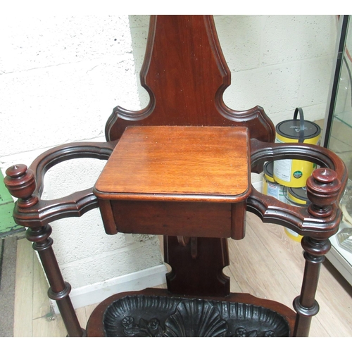 404 - Victorian mahogany hallstand, shaped back with oval mirror and eight coat pegs above a drawer, serpe... 