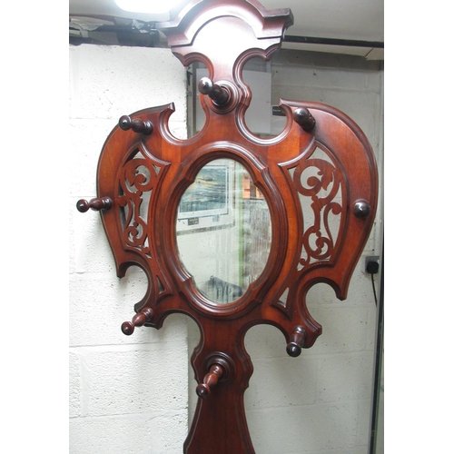 404 - Victorian mahogany hallstand, shaped back with oval mirror and eight coat pegs above a drawer, serpe... 