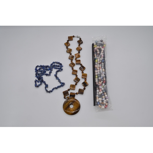 62 - Tiger's eye necklace, 101.9g, clasp stamped 925, a blue amethyst necklace, 31.4g and a string of cul... 