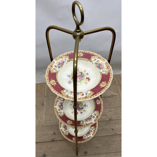 1060 - Edwardian brass three-tier cakestand, with loop handle and three Wedgwood & Co. Vincent pattern plat... 