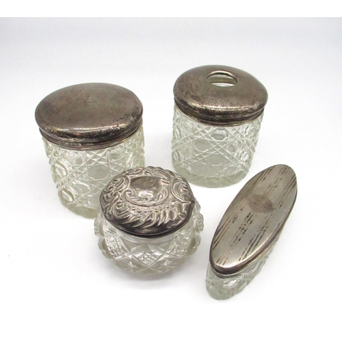 60 - Collection of early C20th cut glass dressing table jars with hallmarked sterling silver lids, gross ... 