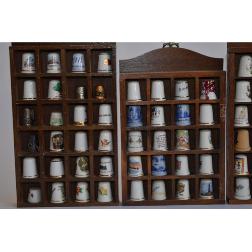 830 - A collection of (mostly) ceramic thimbles with wall hanging display cases, and a glass dome display ... 