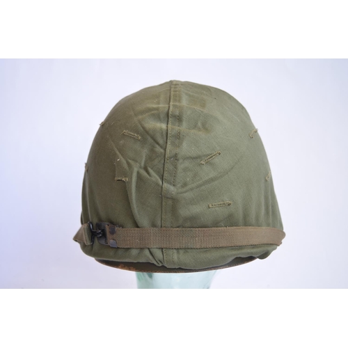 1191 - A US Army M1 Mk2 rear seam steel helmet, with liner, chin straps etc. Helmet has had markings applie... 