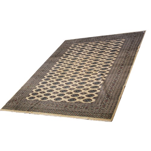 1372 - Bokhara pattern beige ground rug, field filled with stylized elephants foot medallions and stars wit... 