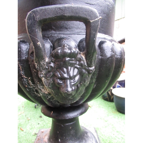 2316 - Large black painted cast iron garden urn with lion head handles and cherubs carrying a garland of fr... 