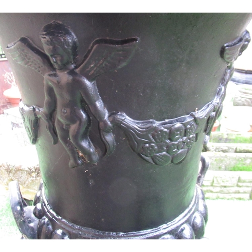 2316 - Large black painted cast iron garden urn with lion head handles and cherubs carrying a garland of fr... 