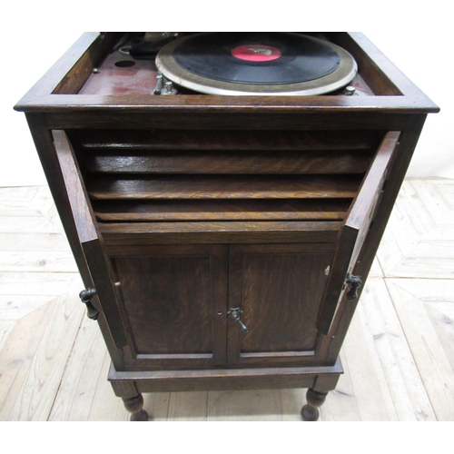 704 - c1920s HMV type oak cased free standing wind-up gramophone, with panelled doors, lower section being... 