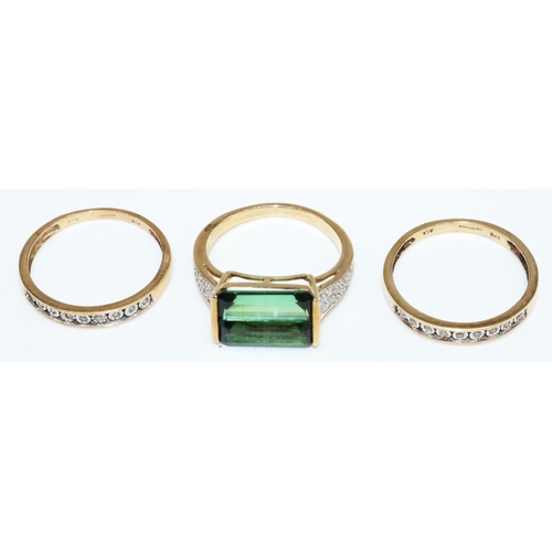 22 - 9ct yellow gold ring set with central emerald cut green stone, the shoulders set with diamonds, stam... 