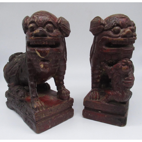 259 - Pair of Chinese carved wooden Dog of Foe candlesticks, on rectangular base, later painted with trace... 