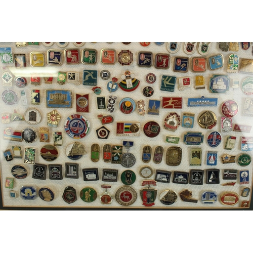 128 - Selection of c1980 USSR enamel badges, mostly relating to Moscow Olympics.  Framed and glazed.