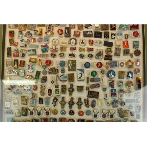 128 - Selection of c1980 USSR enamel badges, mostly relating to Moscow Olympics.  Framed and glazed.