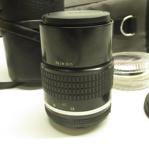 553 - Nikon Nikkor 135mm 1:28 lens with individual black case, lens parts and a grey carry case