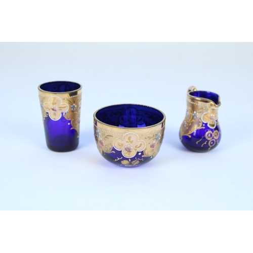 1336 - Early C20th Bohemian blue glass and gilt enamel miniature jug, bowl and beaker set in the manner of ... 