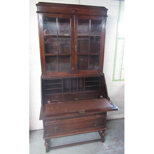 266 - C20th oak bureau-bookcase, two glazed doors and fall front above three drawers on turned supports wi... 