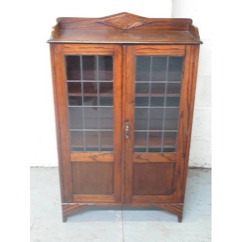 267 - Small C20th oak bookcase, raised back above two part lead glazed doors, on bracket feet, W69cm D25cm... 