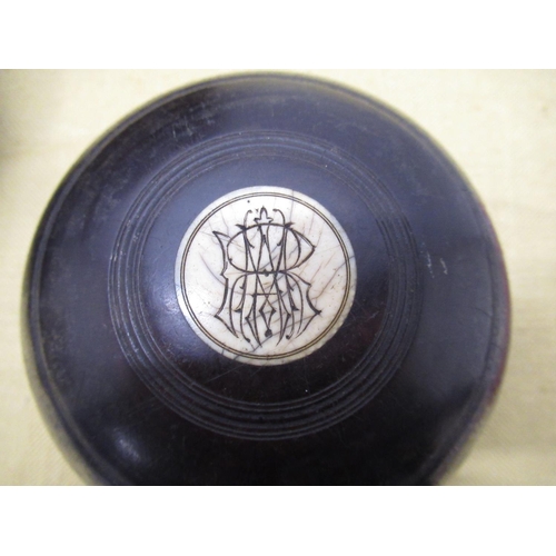 1395 - C20th pair of monogrammed Lignum Vitae bowls, manufacturers mark obscured, together with simulated l... 