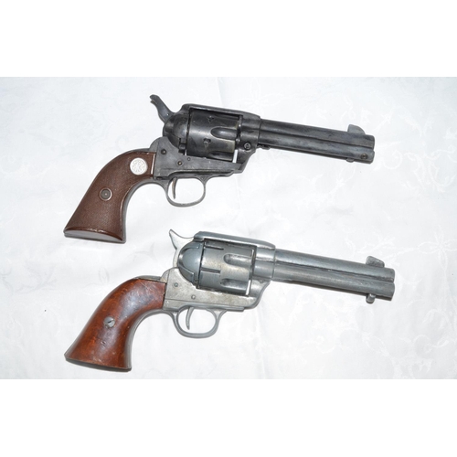 836 - 2 replica metal Colt revolvers, a 44 and 45. The black 44 with working mechanism, the silver 45 hamm... 