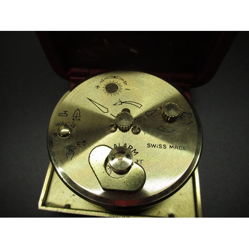 96 - Swiza 8 day travel alarm clock in red leather clam shell case, running, and two miniature brass case... 