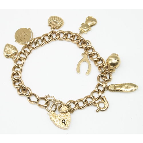1 - 9ct yellow gold charm bracelet with heart padlock clasp and safety chain, with eight 9ct yellow gold... 