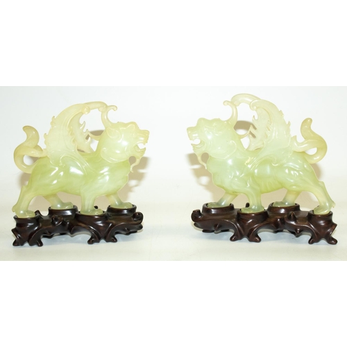 342 - Pair of C20th Chinese carved jade Pixiu winged lion figures, L12cm, with carved wood display stands,... 