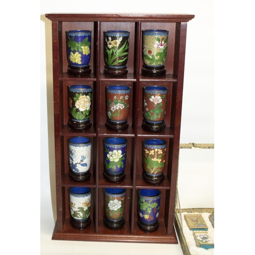 350 - Twelve cloisonne beakers, H7cm, with stands, in wooden display unit, H50.5cm, a boxed set of eight c... 