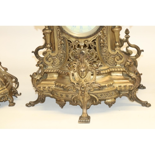 534 - Early 20th century brass clock garniture, comprising central clock in extensively cast brass case wi... 