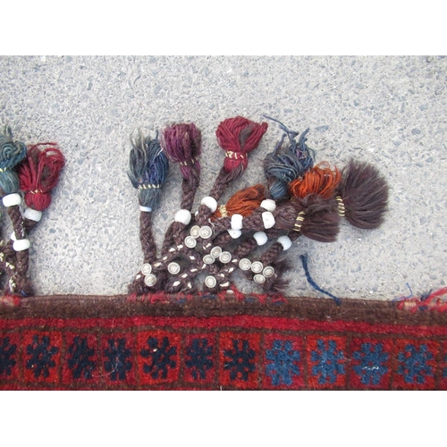 312 - Afghan saddlebag cushion, medallion field with repeating border and part beaded fringe, 100cm x 60cm