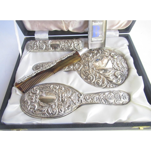 321 - Cased four piece Birmingham silver hallmarked backed dressing table brush and mirror set with emboss... 