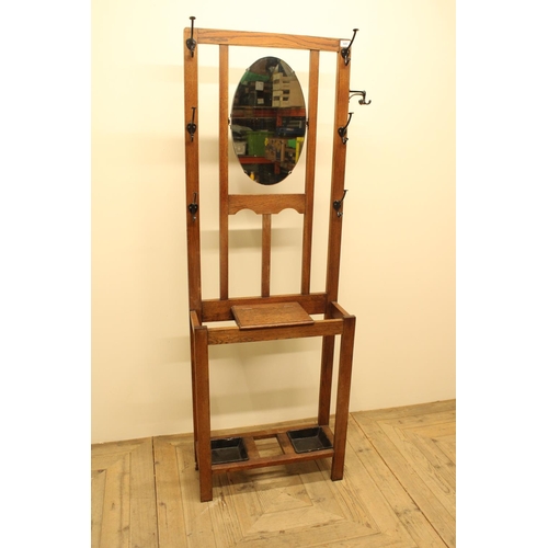 645 - C20th oak mirror back hall stand, 6 metal hooks and 2 swivel metal hooks, above two umbrella and sti... 