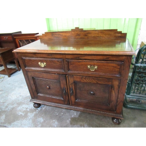 694 - Small Oak dresser, with stepped low raised back above two drawers and two panelled doors on bun feet... 