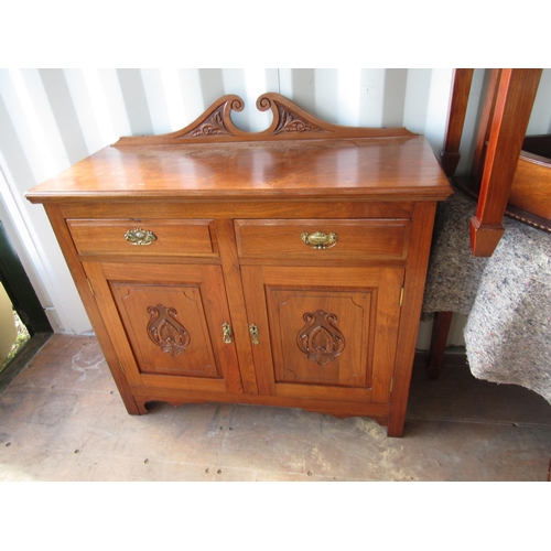 682 - Edwardian walnut side cabinet, scroll galleried back above two drawers and two carved panel drawers ... 