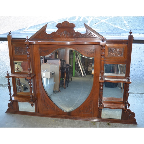 683 - C20th walnut overmantle mirror with shield shaped bevelled mirror and four shelves with turned suppo... 