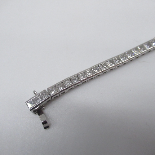 1000 - 18ct white gold tennis bracelet with tongue and box closure, set with 64 princess cut diamonds, stam... 