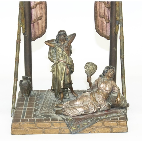 1128 - After Franz Bergman: a painted spelter table lamp in the form of two females on rugs on tiled floor ... 