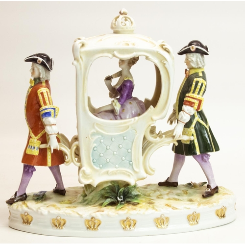 1088 - Continental porcelain model of a young girl in a sedan chair supported by two porters, on oval natur... 