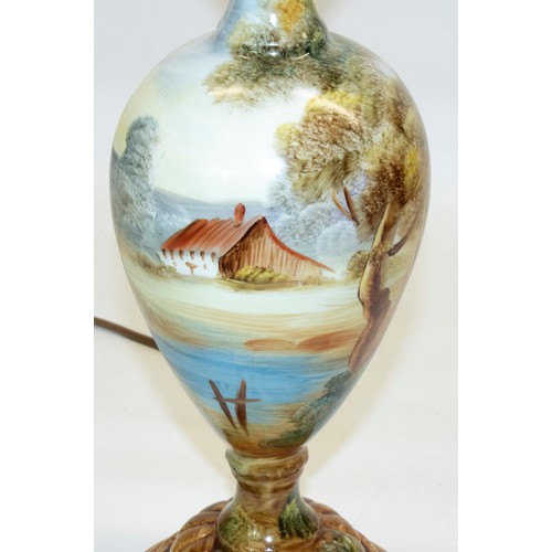 1090 - Continental porcelain table lamp, circular tapering body painted with cottage in wooded river landsc... 