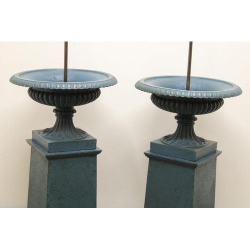 1455 - Pair of cast iron campana shaped garden urns, lobed bodies on fluted supports and square bases, tape... 