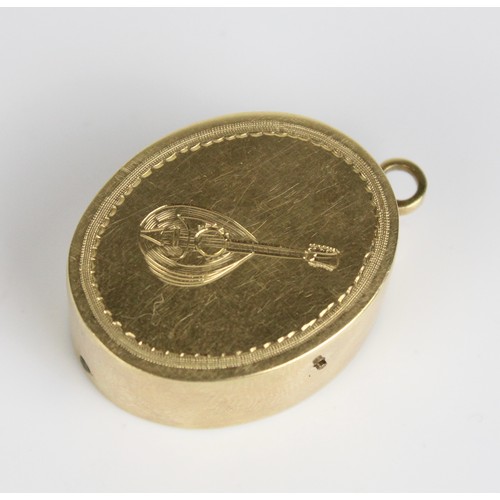 1028 - Early C20th oval yellow metal musical box, with lute decoration (missing key), 31.2g, with two unmat... 