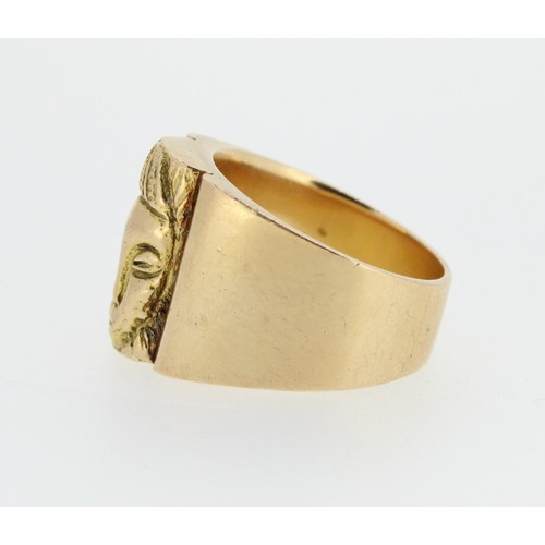 1025 - Yellow metal ring with tribal mask decoration, on plain band, size T, 22.8g