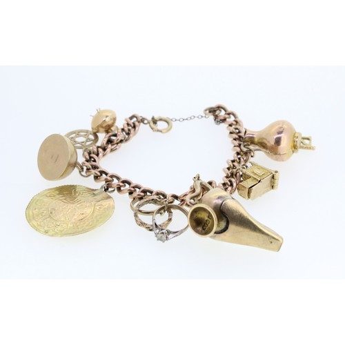 1009 - 9ct yellow gold charm bracelet stamped 375, set with 9ct yellow gold and yellow metal charms, includ... 
