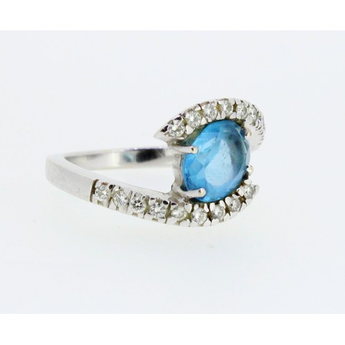 1021 - 18ct white gold twist ring, the central oval cut blue topaz in claw setting, on diamond set twist sh... 