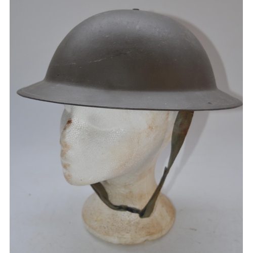 713 - Wartime British steel helmet with chinstrap, stamped on lip B56 1SLO