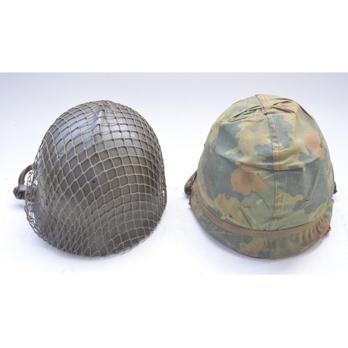 724 - US Army Vietnam era M1 steel helmet with liner and chinstrap and a repainted hard plastic Belgian ri... 