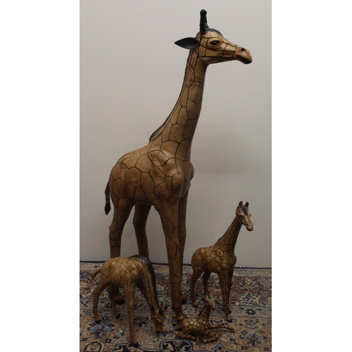 134 - Four painted leather covered model giraffes, max. H103cm, African carved wood items, etc.