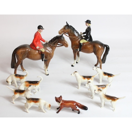 Beswick Hunting group of Huntsman and Huntswoman on brown horses with eight hounds and a running fox
